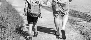 Boy and adult walking and holding hands